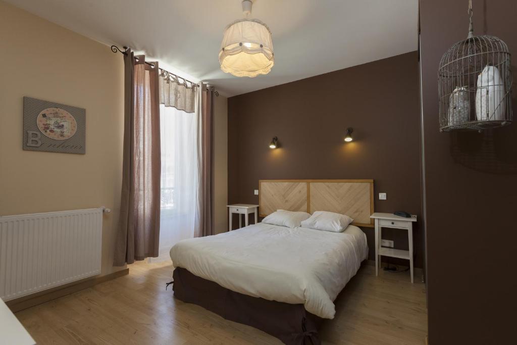 勒布罗伊斯阿尔卑斯酒店的一间卧室配有一张大床和吊灯