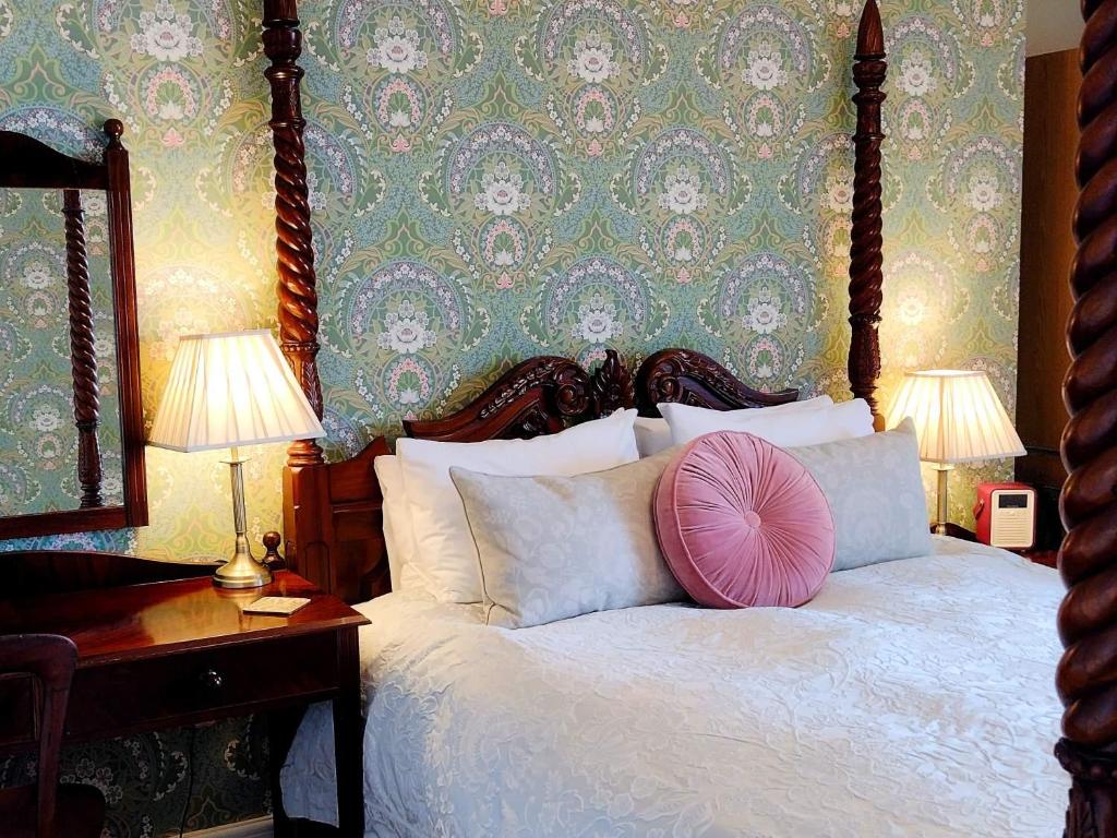 林顿鸦巢酒店的一间卧室配有一张带粉红色枕头的床