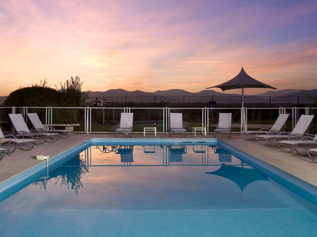 科尔马科尔马北宜必思尚品酒店的一个带躺椅和遮阳伞的游泳池