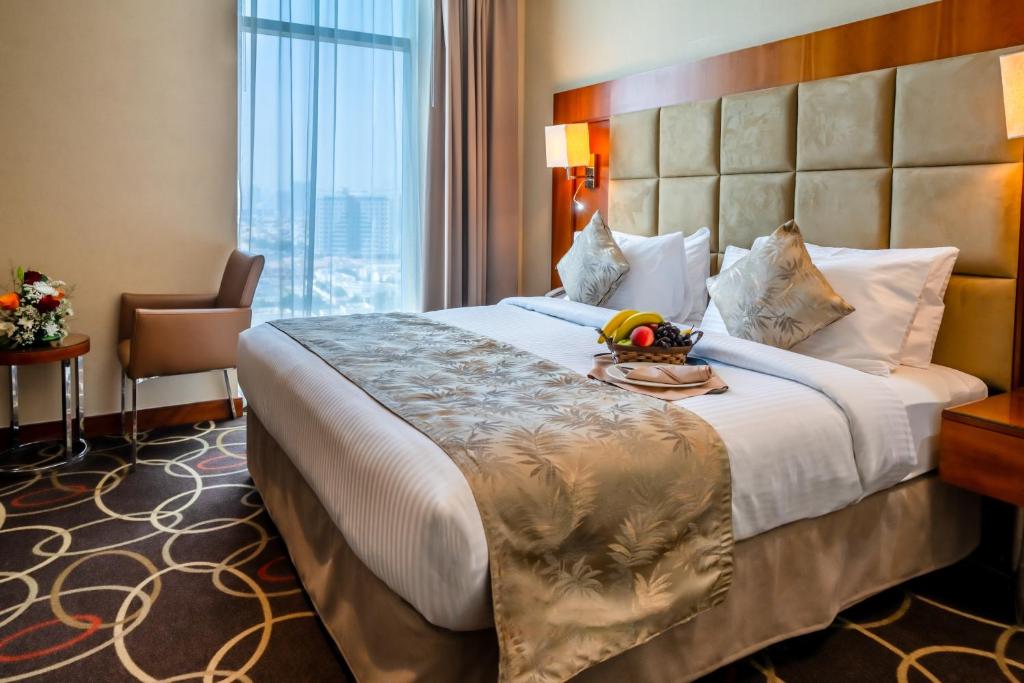 迪拜Montreal Barsha Hotel的一间设有大床和窗户的酒店客房