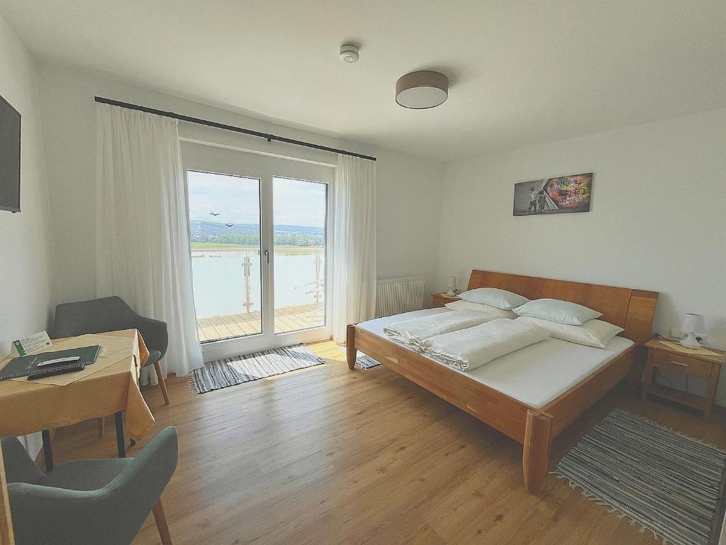 LeibenGasthaus Donaublick的一间卧室设有一张床和一个大窗户