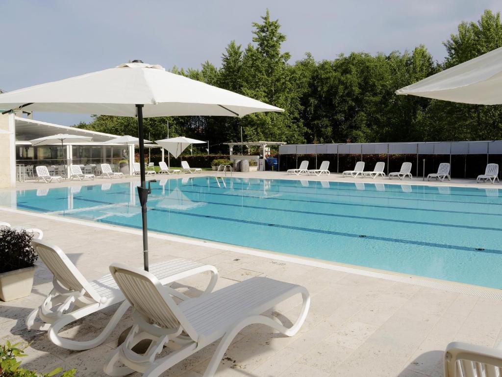 阿雷佐Hotel Arezzo ASC的游泳池旁配有椅子和遮阳伞