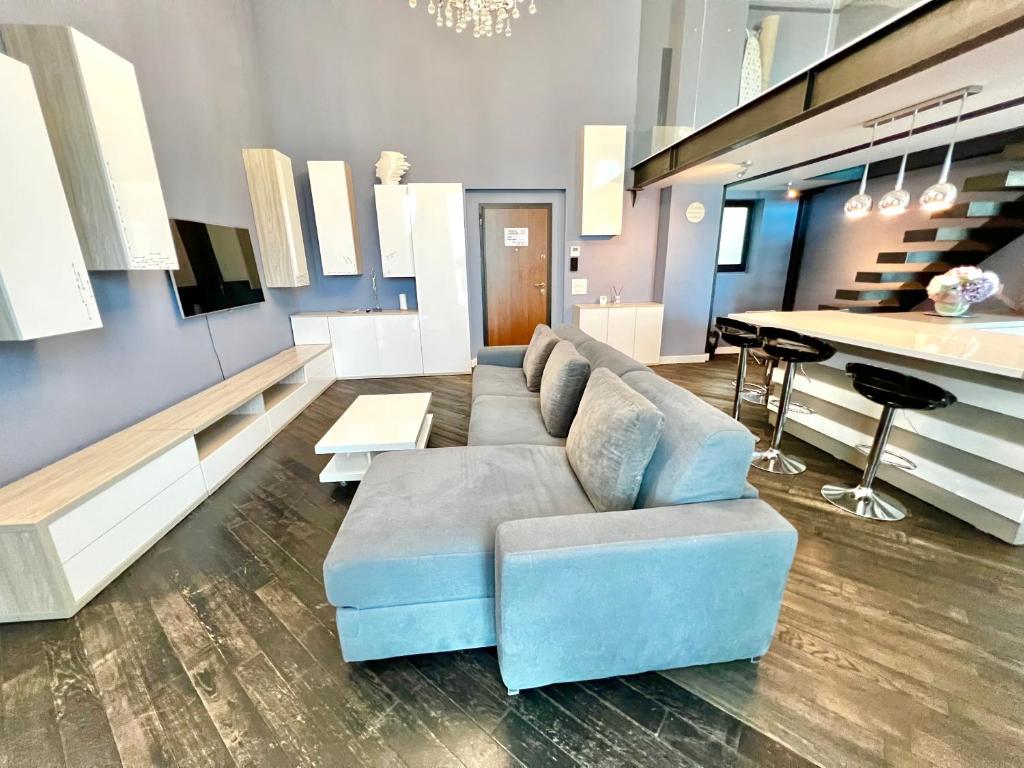 马马亚Blue Bike Seaview Apartment & Penthouse的一间带蓝色沙发的客厅和一间厨房