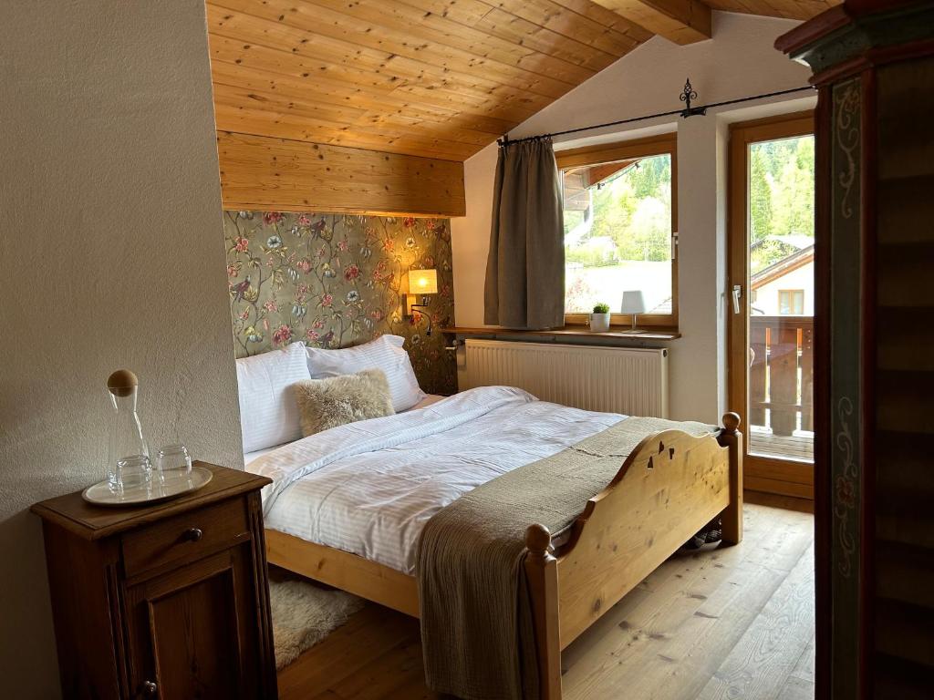 埃尔瓦尔德Das Halali - dein kleines Hotel an der Zugspitze的一间卧室设有一张带木制天花板的大床
