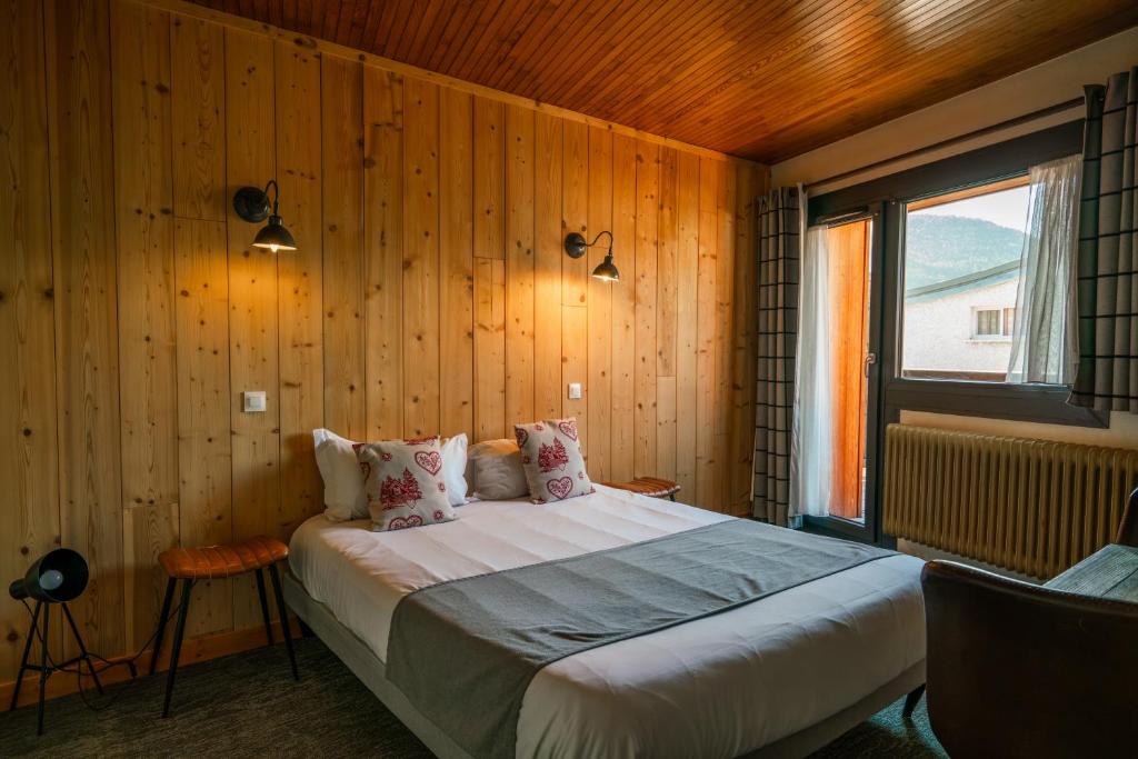 莱德萨阿尔卑斯Chamois Lodge的一间卧室配有一张带木墙的大床