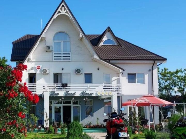 BasarabiTina Guest House的一辆停在前面的摩托车白色房子