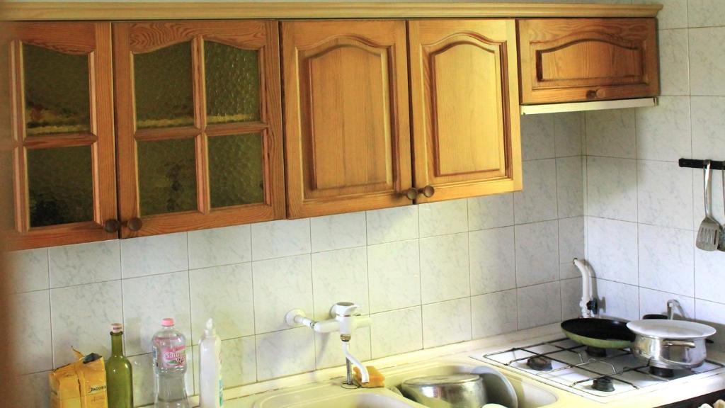 波罗斯洛Zsigmond Ház的一个带木制橱柜和水槽的厨房台面