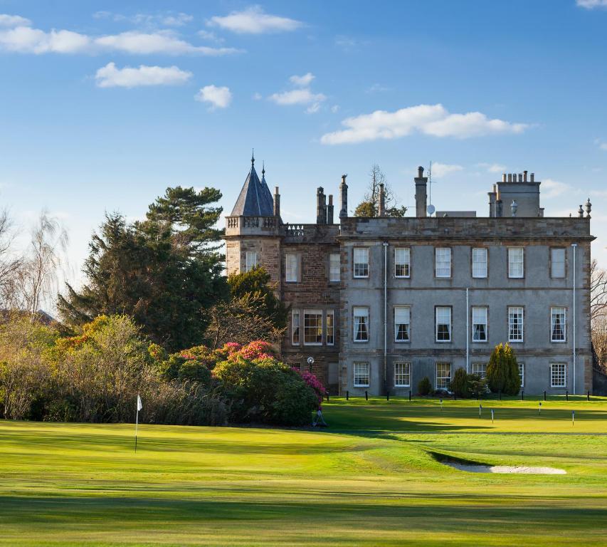 爱丁堡戴玛荷酒店及乡村俱乐部的一座古老的城堡,拥有一座绿色的庭院和一个高尔夫球场