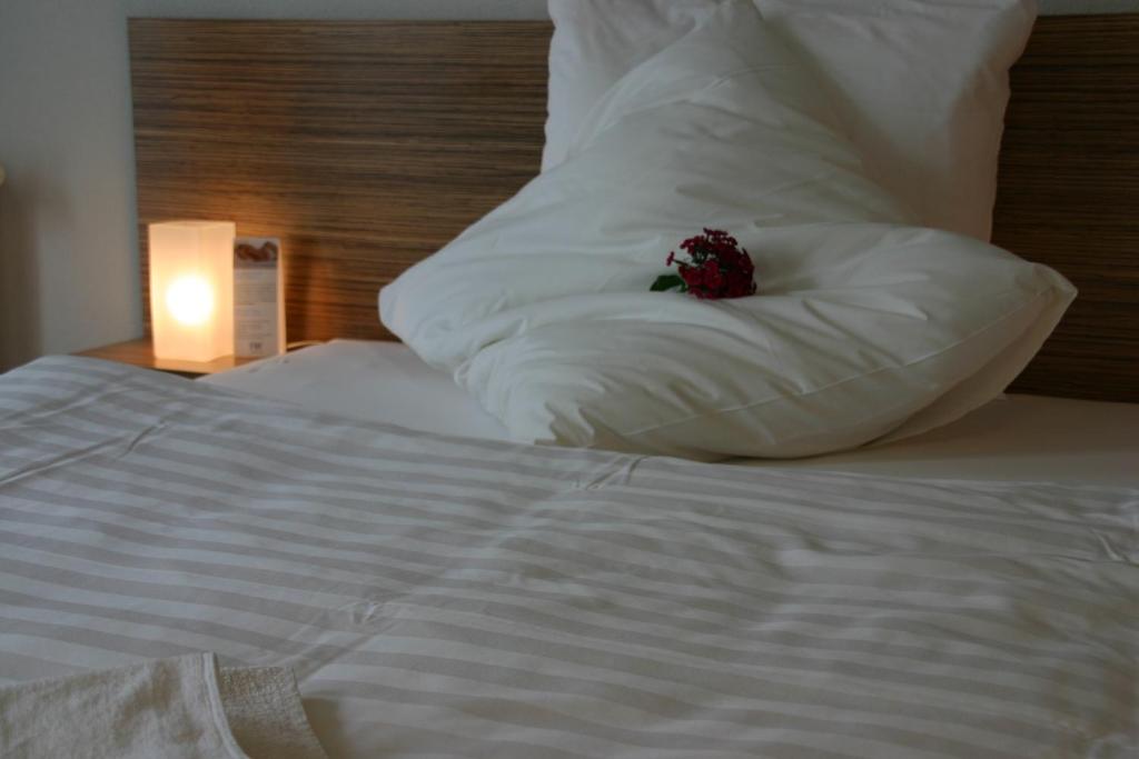 拉德博伊尔菲尔恩豪弗迪特池尔本酒店的一张白色的床,上面有枕头,上面有花