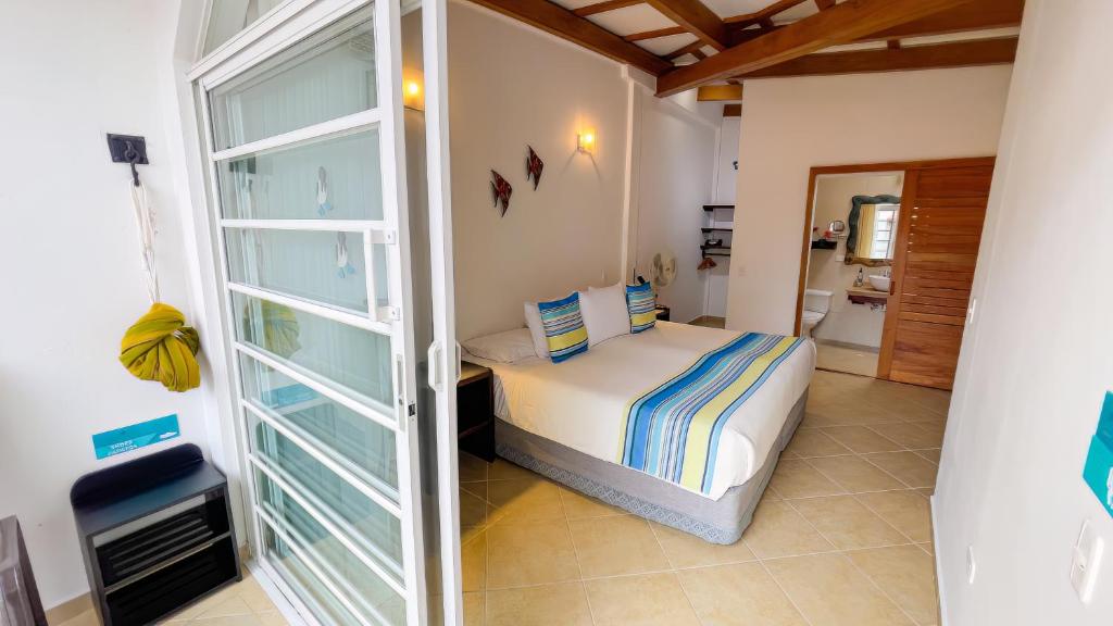 阿约拉港加拉帕戈斯套房住宿加早餐旅馆的一间卧室设有一张床和一个玻璃门
