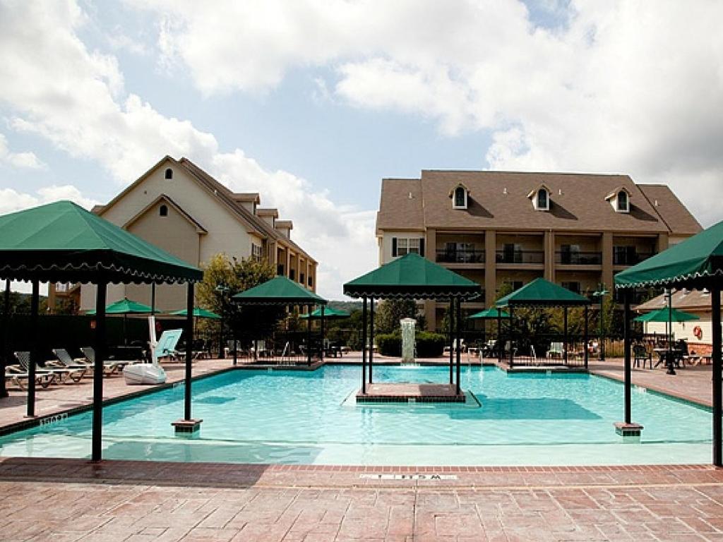 布兰森法语区度假酒店的大楼前带绿伞的大型游泳池