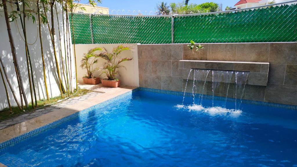 莫雷洛斯港Vela's Condos Ocean Front的庭院中一个带喷泉的游泳池