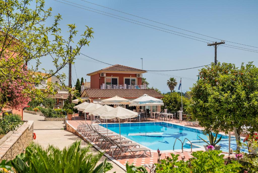 古维亚Marietta's Resort by Konnect, Gouvia Corfu的度假村的游泳池,配有椅子和遮阳伞
