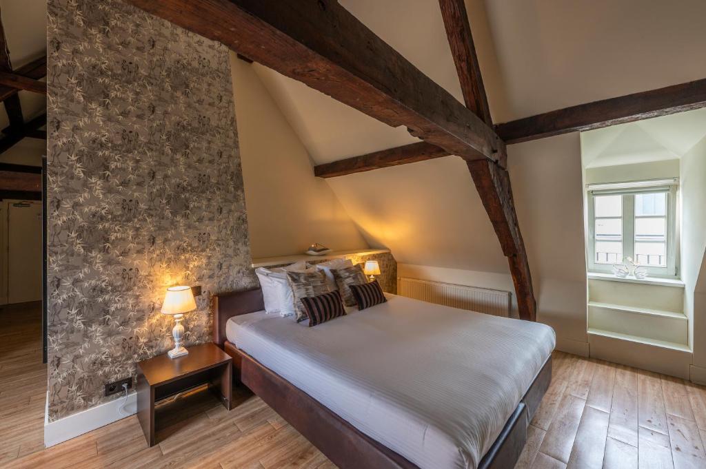 根特奥德伯根酒店的一间卧室设有一张床和石墙