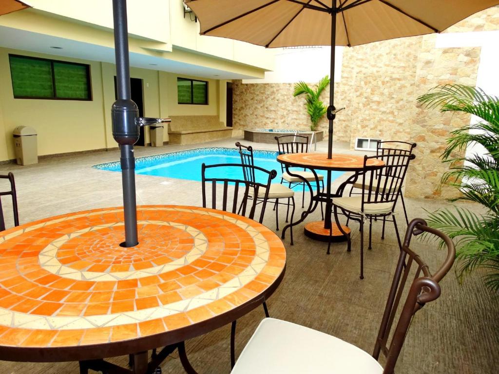 萨利纳斯马尔温托套房酒店的一个带桌椅的庭院和一个游泳池