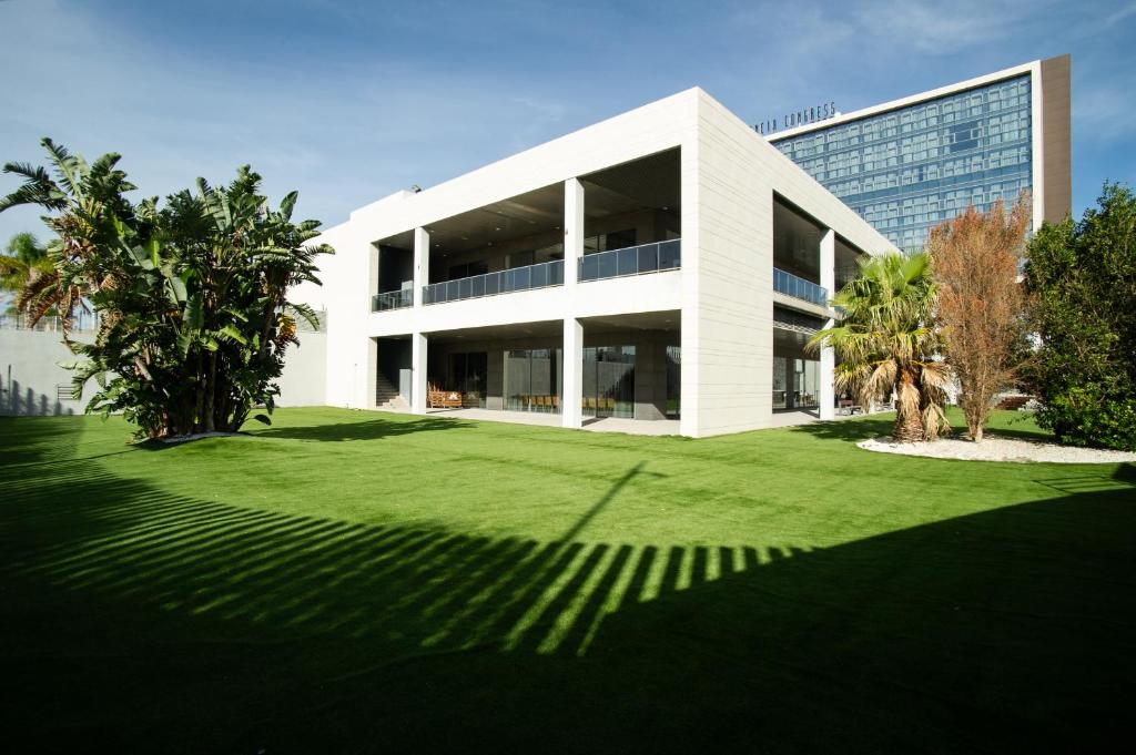 帕特纳AZZ Valencia Congress Hotel & Spa的前面有草坪的白色大建筑