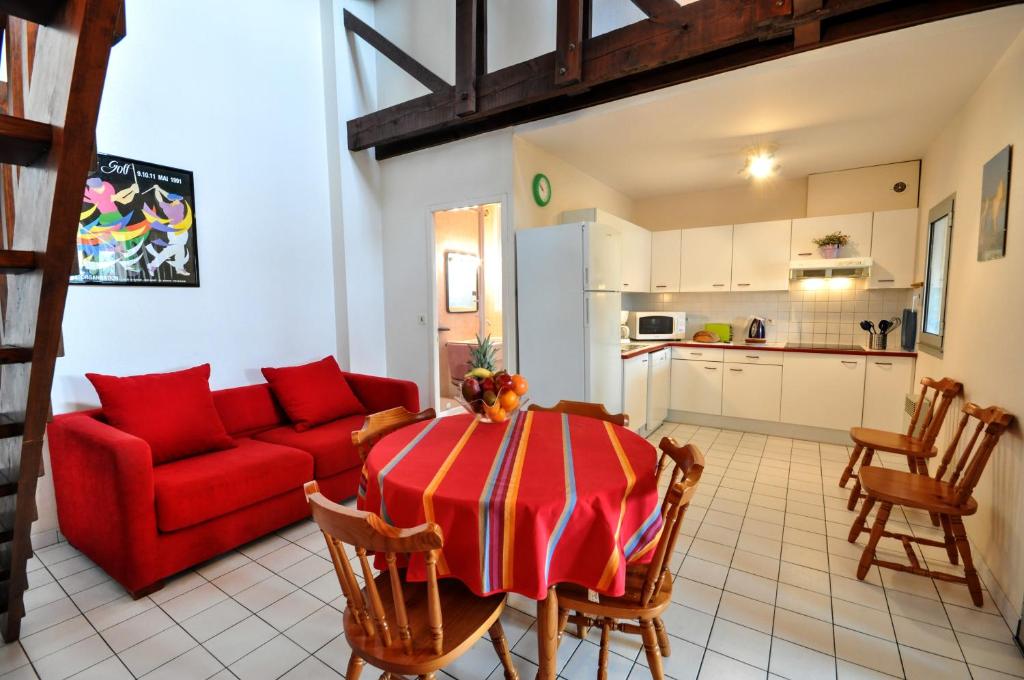 布科·莱斯白老城阿基坦公寓的客厅配有红色的沙发和桌子