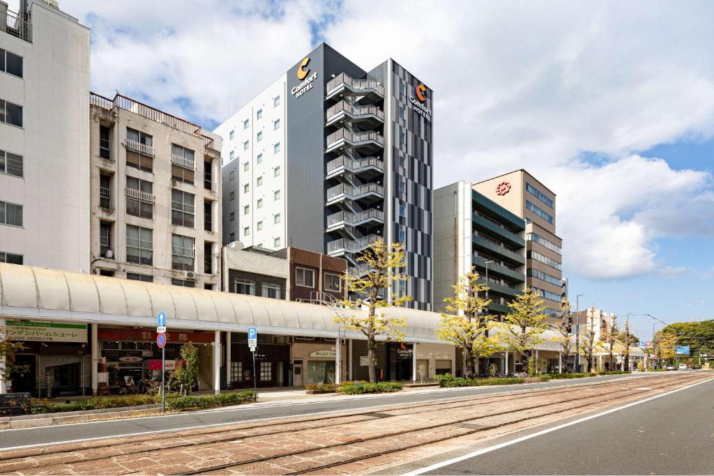 松山Comfort Hotel Matsuyama的一条空荡荡的城市街道,有高大的建筑和道路