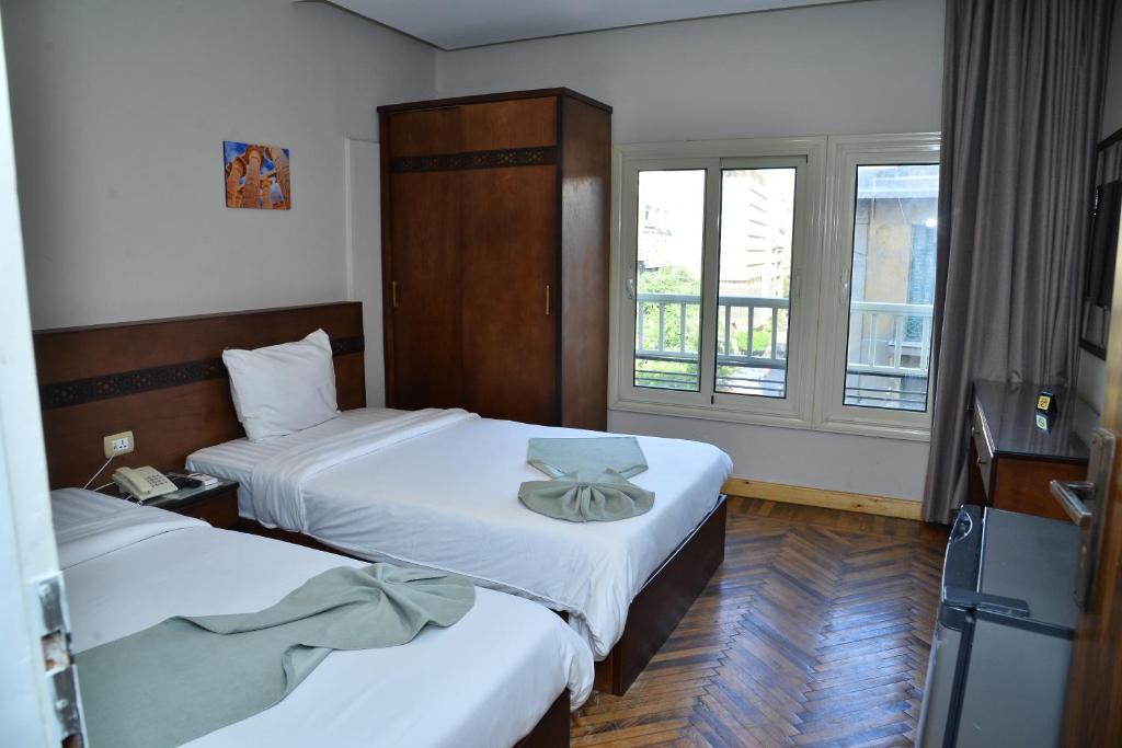 开罗Miramar Evergreen Hotel的酒店客房设有两张床和窗户。
