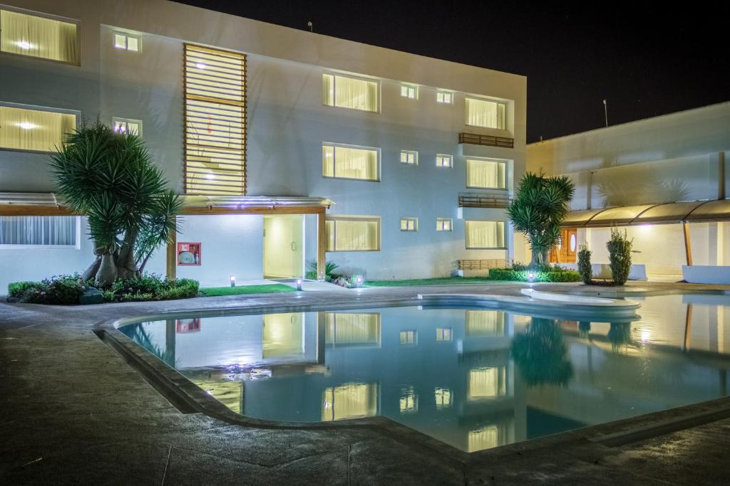 伊瓦拉Hotel Ajavi的一座游泳池,在晚上在建筑物前