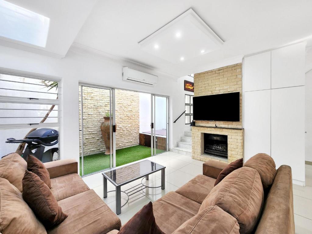 开普敦Urban Style House with Jacuzzi & Garage的带沙发和壁炉的客厅