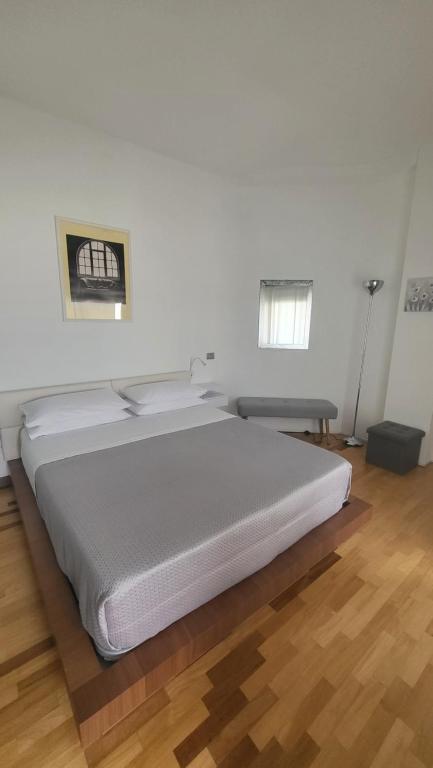 米兰San Siro Terrace Attic Apartment Milano的铺有木地板的客房内一张大白色的床