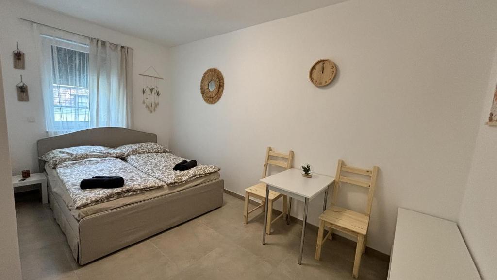 LangenzersdorfLangenzersdorf Apartment的一间卧室配有一张床、一张桌子和闹钟