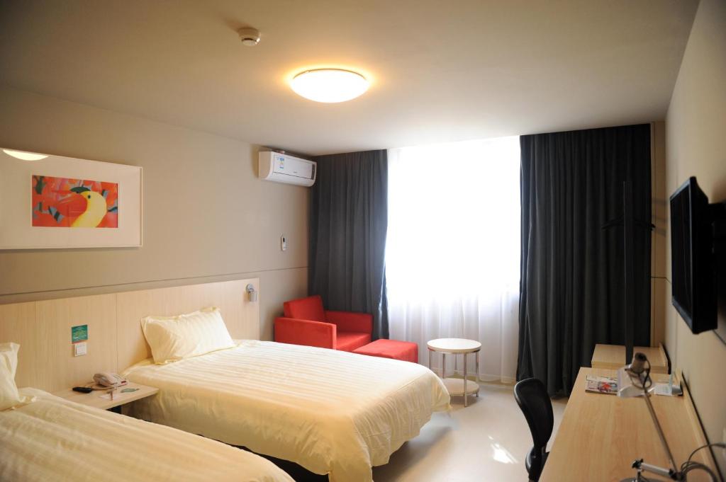 上饶锦江之星上饶中山路店的酒店客房,配有一张床和一张红色椅子