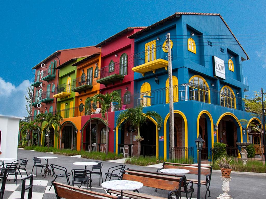 蔻立卡萨库尔酒店的一座色彩缤纷的建筑,前面设有桌椅