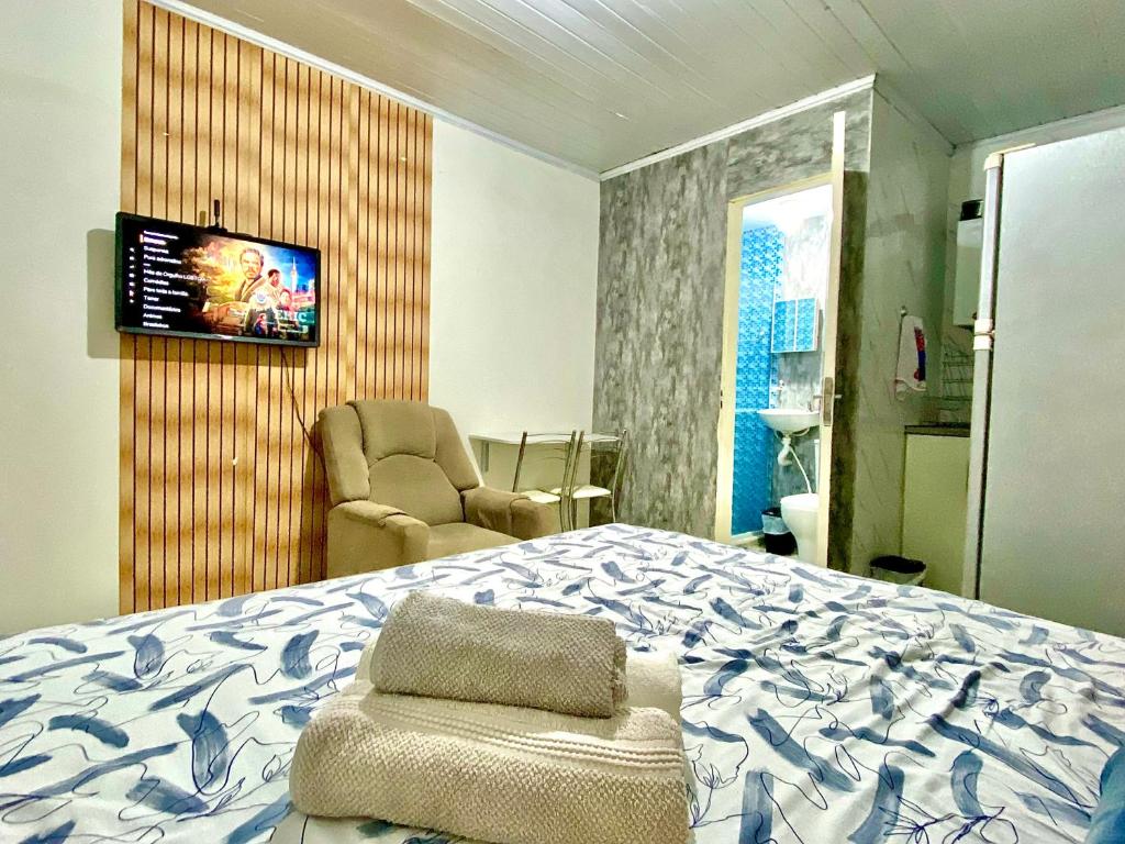 萨尔瓦多Kitnet Completa Centro Histórico的一间卧室配有一张床、一把椅子和电视。