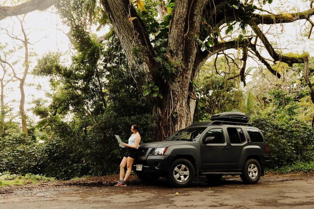 卡胡卢伊Roadtrip Camping on Maui的站在树旁的黑苏夫旁边的女人
