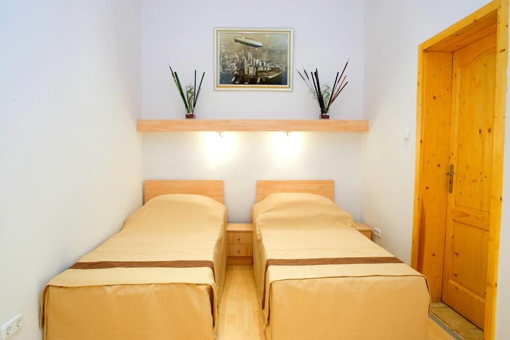 布达佩斯珊特罗姆斯酒店的小型客房的两张床,设有门