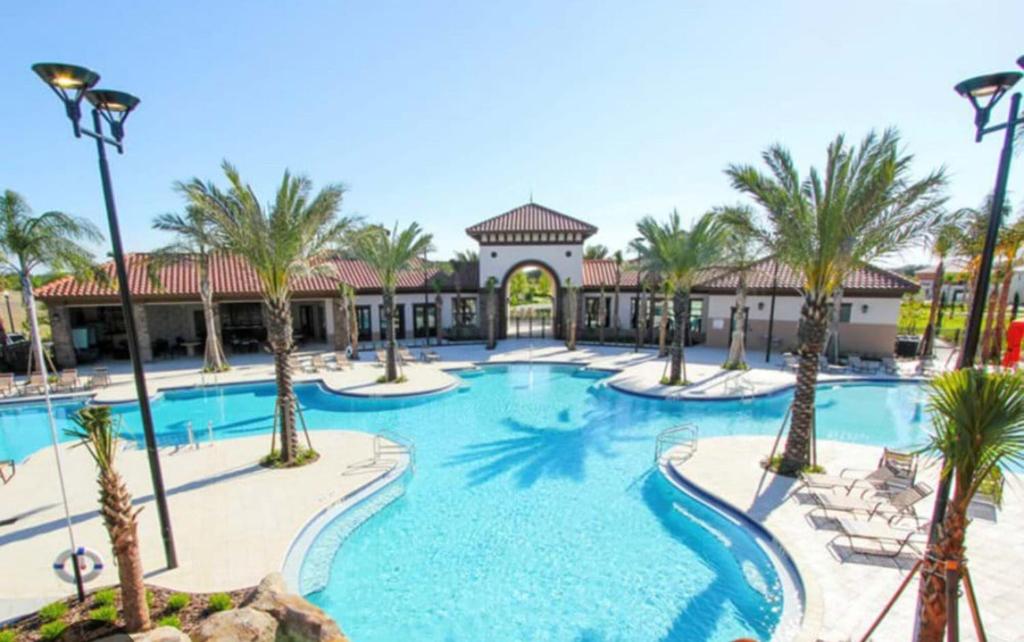 达文波特Orlando Relax的棕榈树和椅子的度假村的游泳池