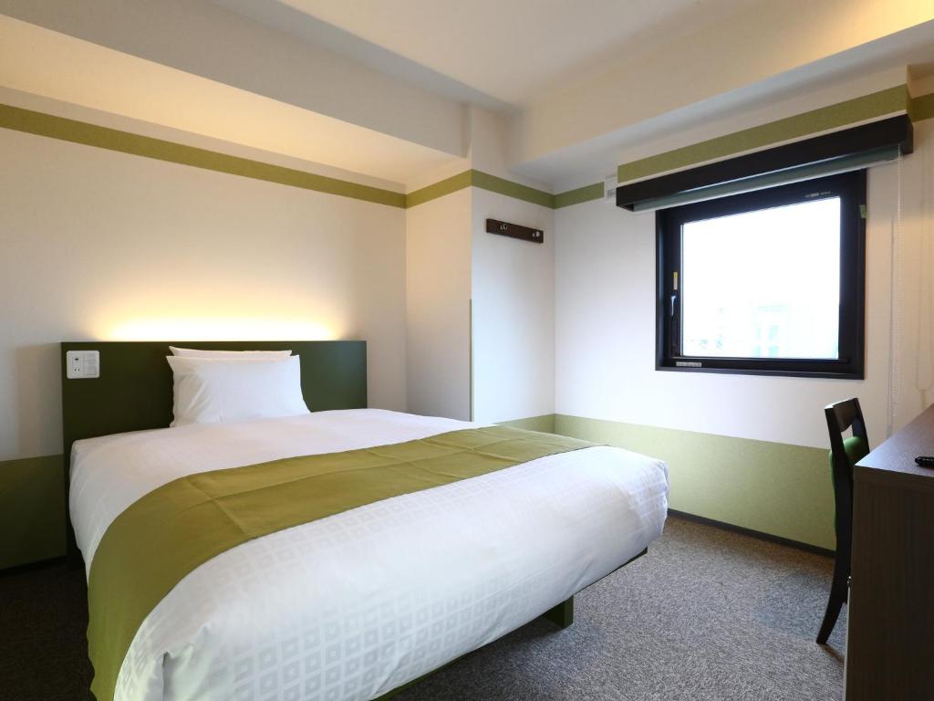 东京上野御徒町永国国际精选酒店的一间卧室设有一张大床和窗户
