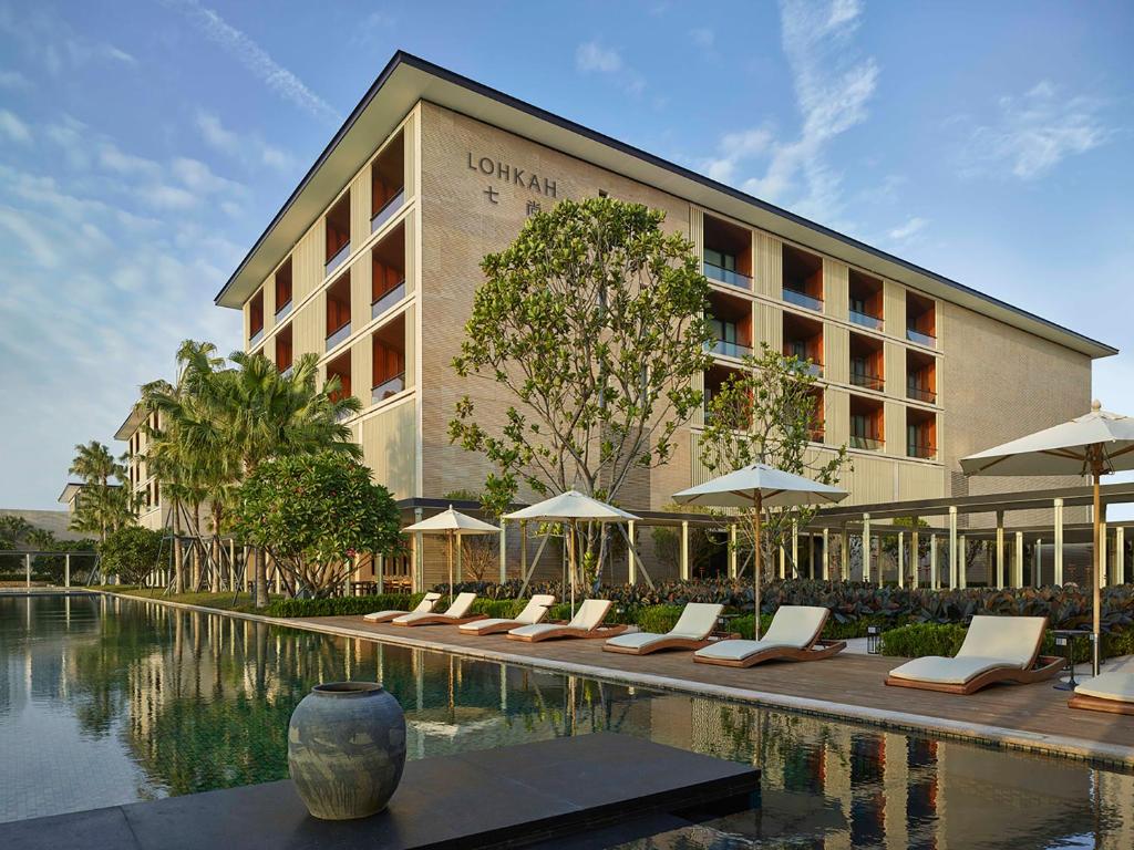 厦门厦门七尚酒店（奢享水天一色湾景）的游泳池旁设有一排躺椅的酒店