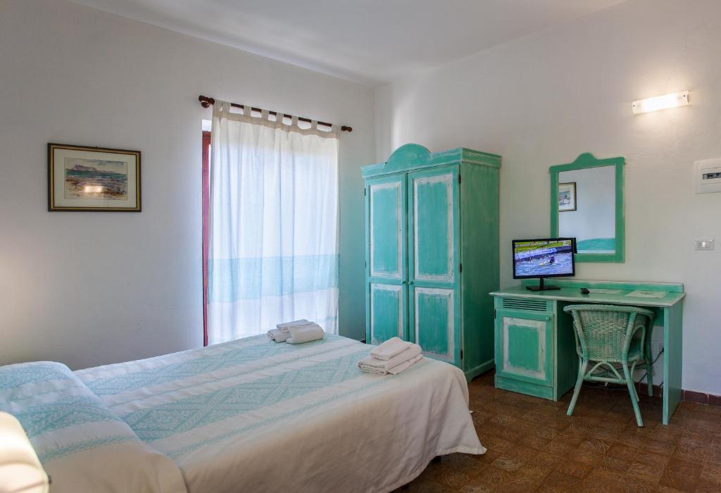 圣特奥多罗Hotel Sandalyon的一间卧室配有一张床和一张带电脑的书桌