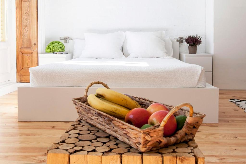 马德里马图特11号公寓的一张桌子上一篮子的水果,放在床边