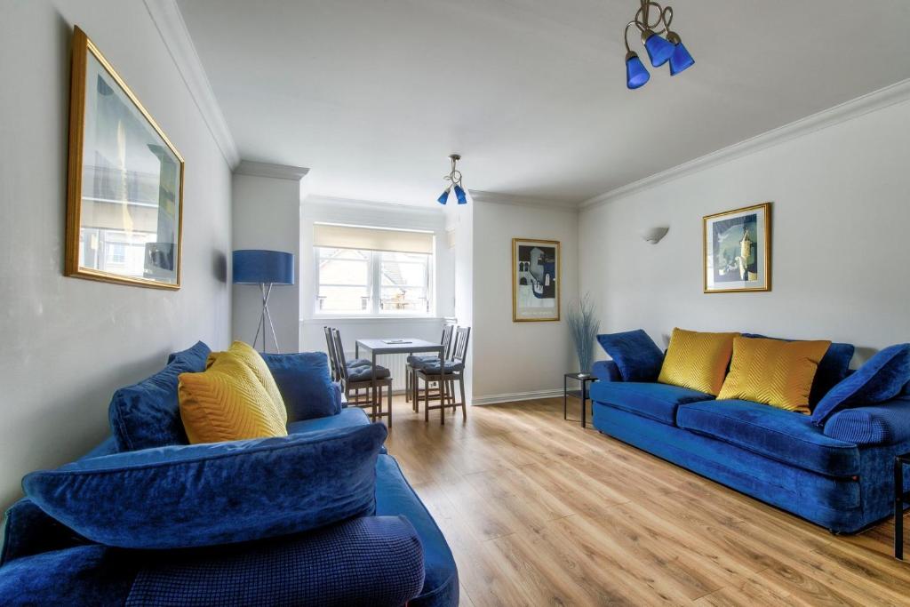 爱丁堡GuestReady - Stylish Apt w/ Parking near Edinburgh的客厅配有2张蓝色的沙发和1张桌子