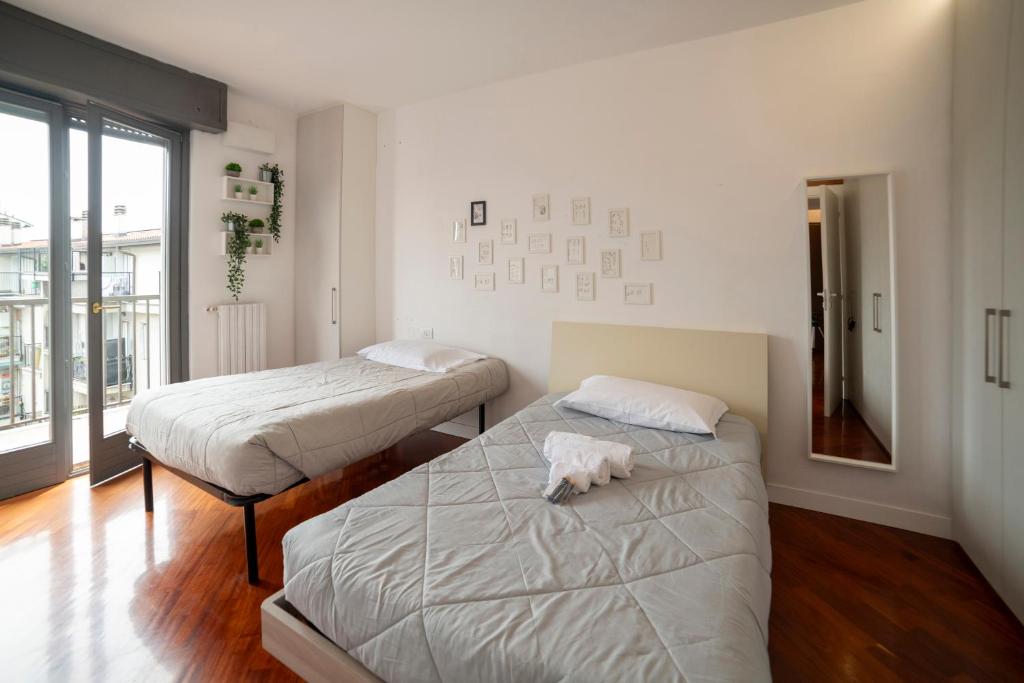 米兰VILLA FENIX MILANO的一间卧室设有两张床,床上有一只狗