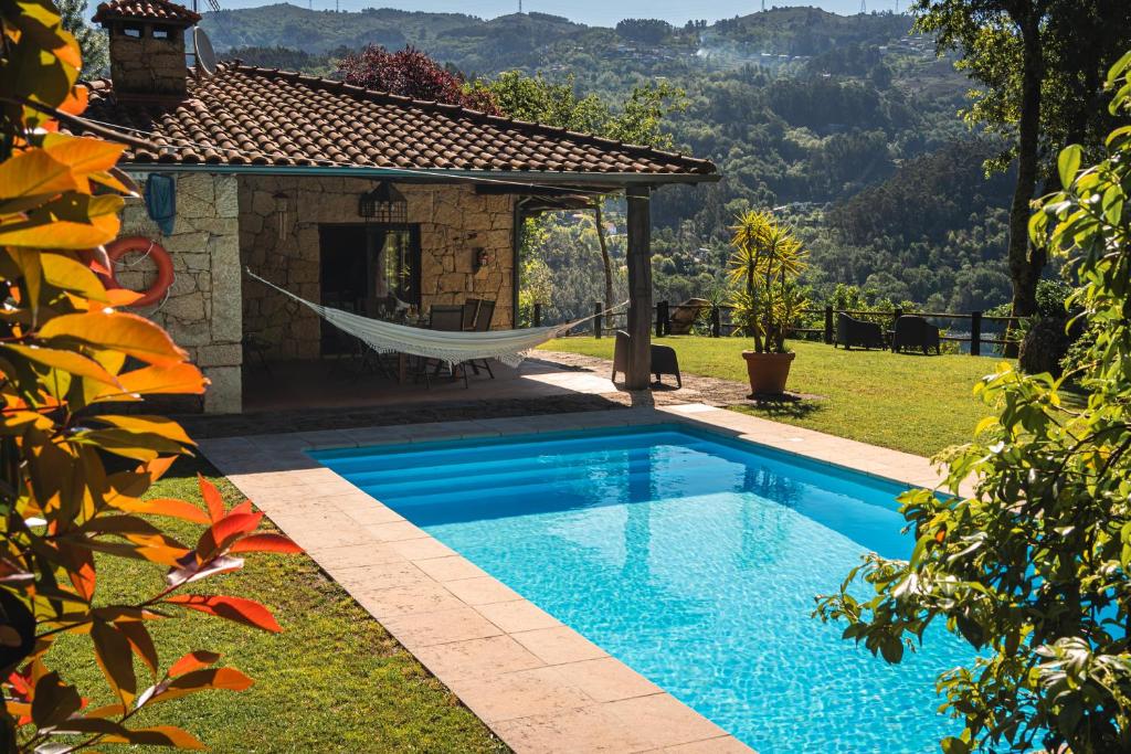 吉尔斯Casa da Terra - Gerês的房屋旁带吊床的游泳池