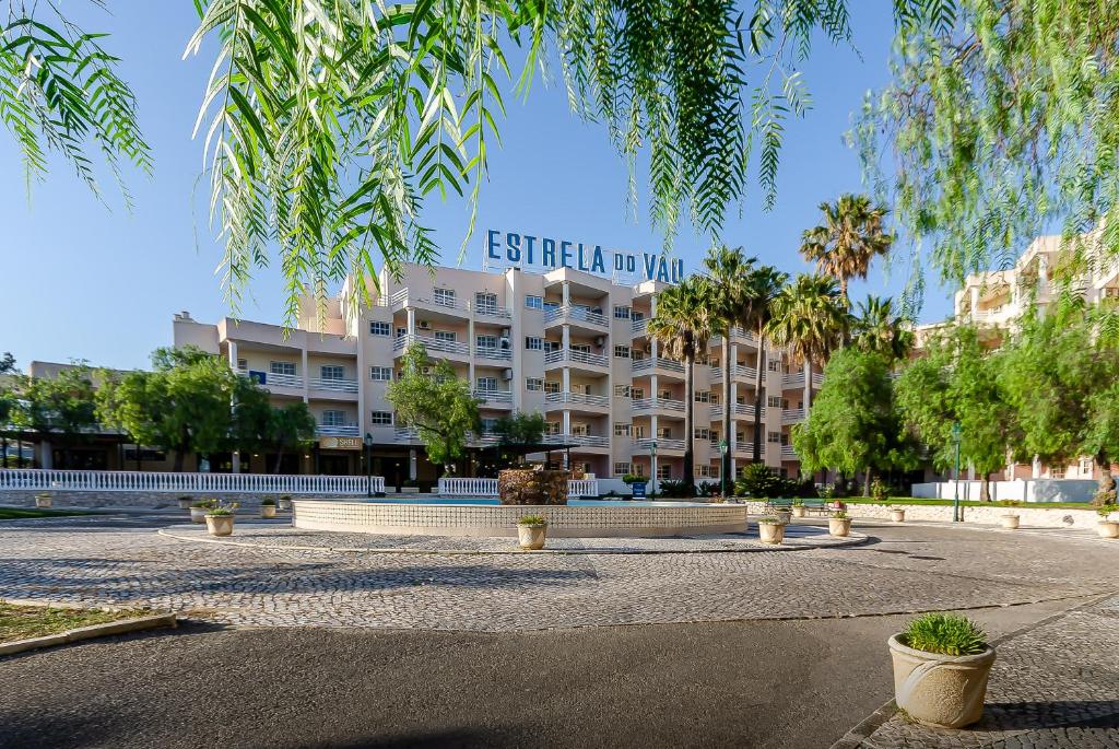 波尔蒂芒TURIM Estrela do Vau Hotel的前面有树木的白色大建筑