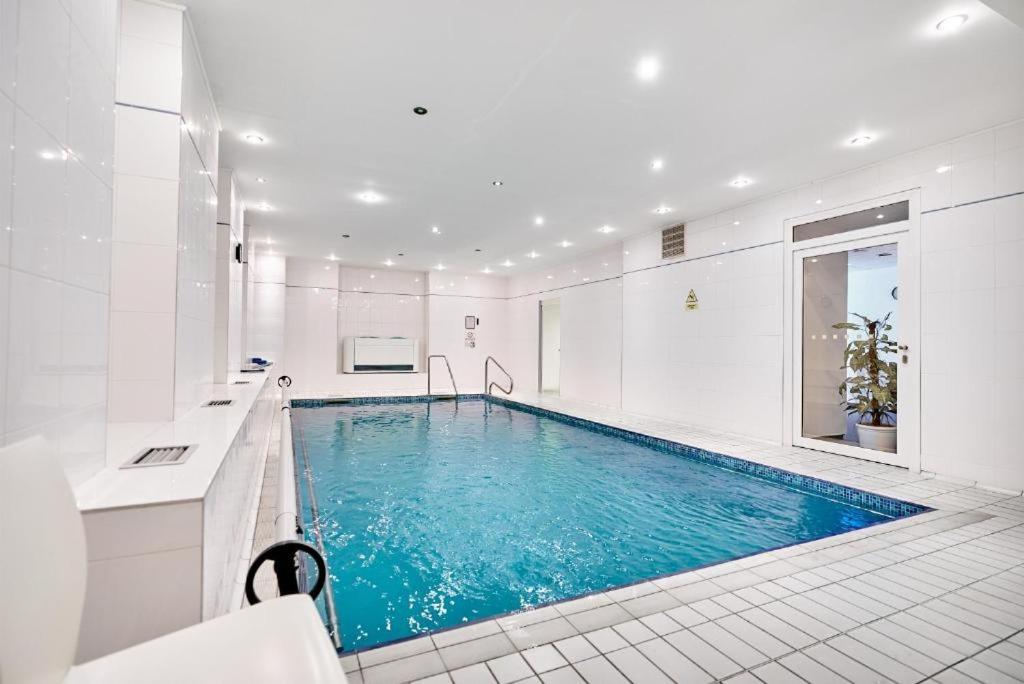 玛丽亚温泉夫罗拉酒店的白色浴室内的大型游泳池,蓝色的游泳池