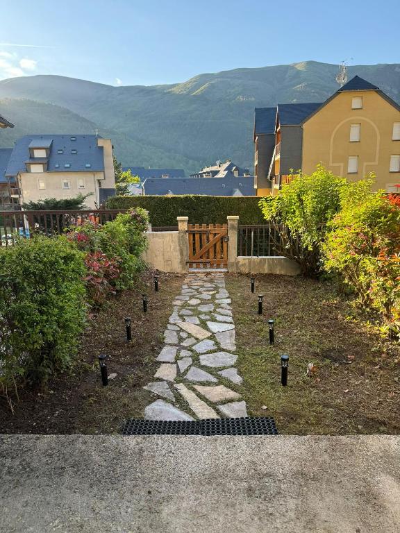 圣拉里苏朗Appartement Saint Lary Soulan centre-ville的一个带石头小径和围栏的花园