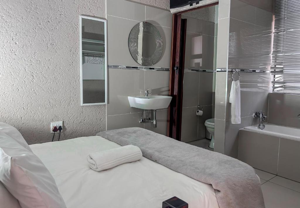 内尔斯普雷特View Inn Exclusive Lodge的白色的浴室设有床和水槽