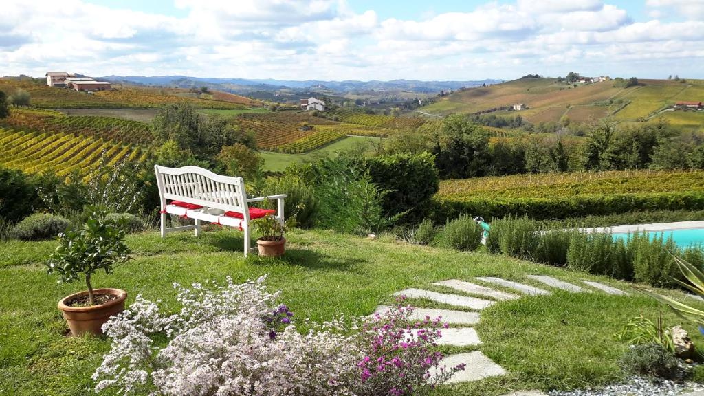 Fontanile卢瑟索尔乡村民宿的坐在游泳池旁的草上的一个白色长凳