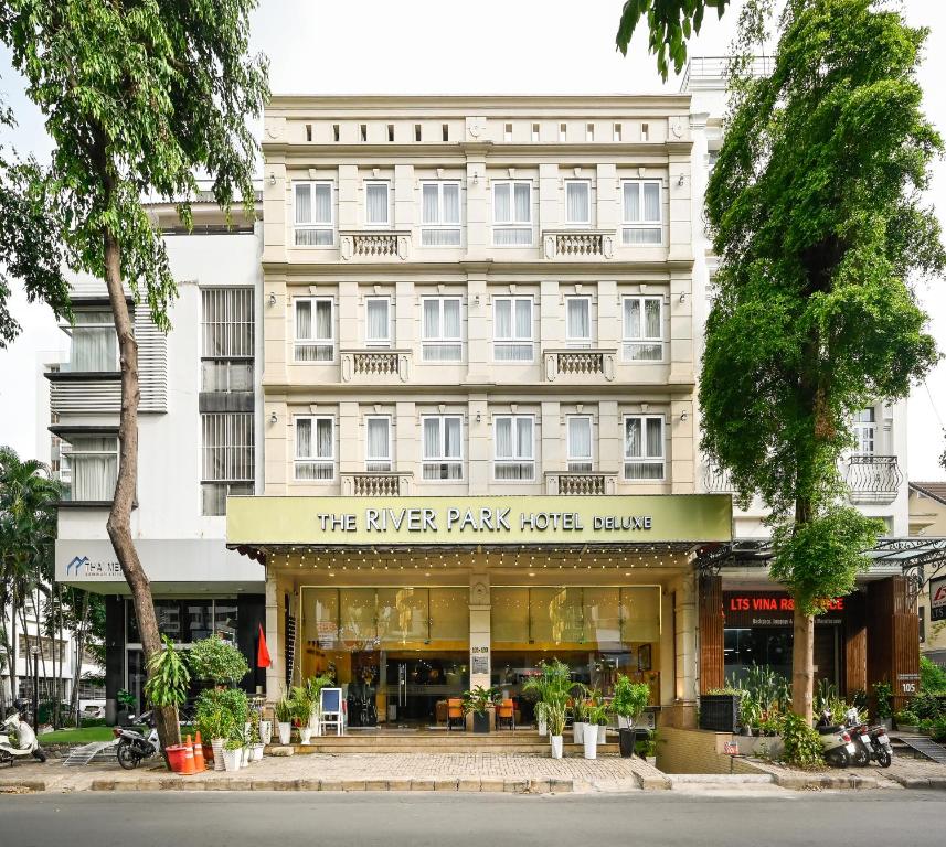 胡志明市The River Park Hotel的一座大型的白色建筑,设有商店