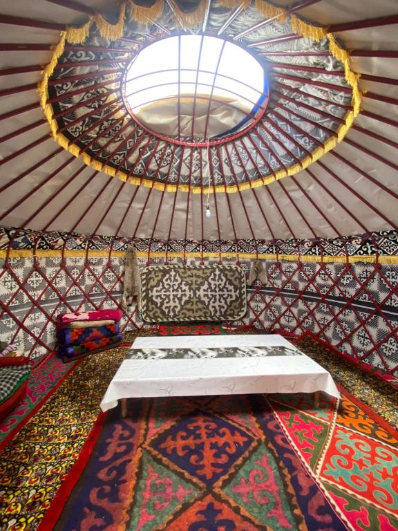 科奇科尔Nomad Guest House的一间帐篷内带床和窗户的房间