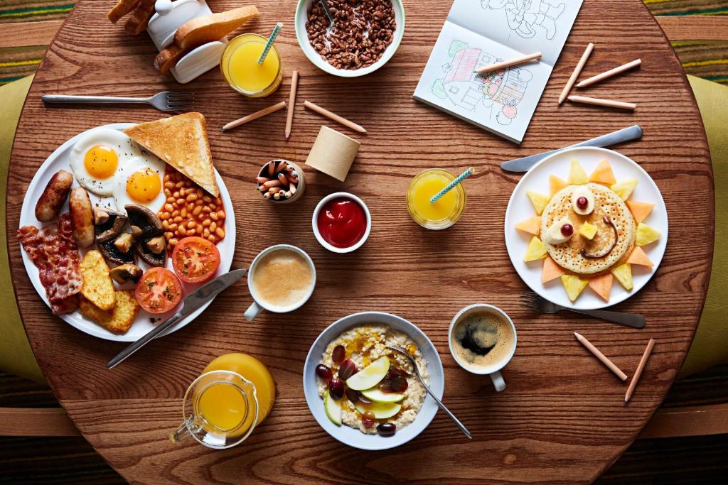 阿布扎比Premier Inn Abu Dhabi Airport Business Park的一张木桌,上面放着早餐食品