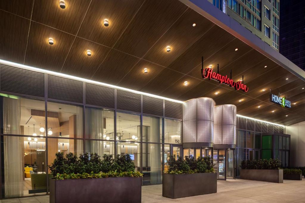 纽约Hampton Inn by Hilton New York Times Square的前方植物建筑前的商店