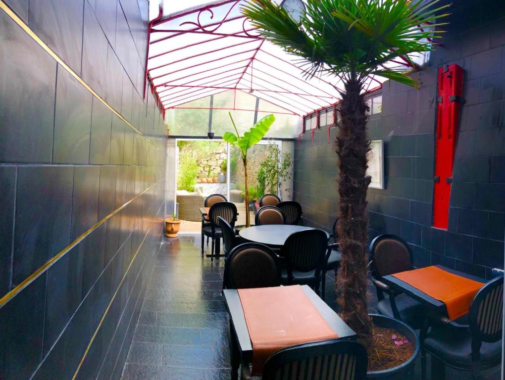 拉昂布弗莱特旅馆的一间设有桌椅的餐厅,并种植了棕榈树